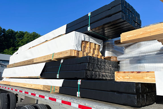Finger-joined Nail-Laminated columns with treated bottoms and Green Post on truck bed