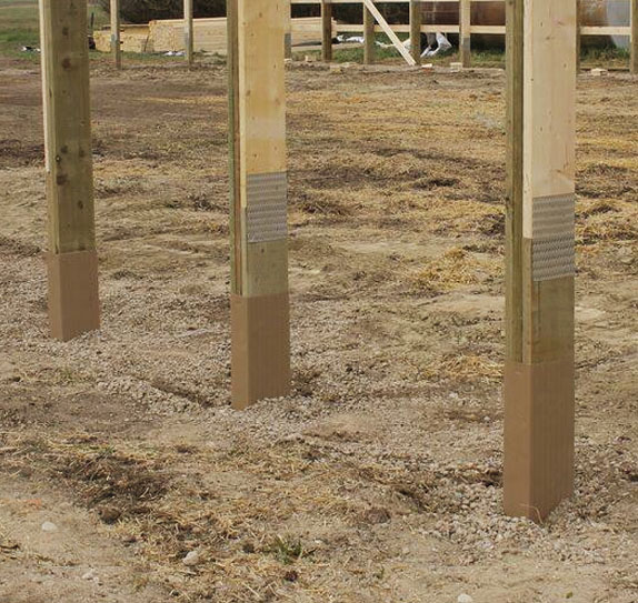 Post-frame columns construction site with clay tone color and wood grain texture